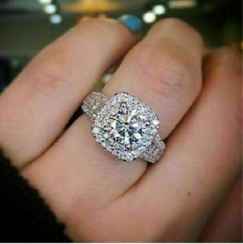 a close up of a person's hand with a diamond ring on their finger