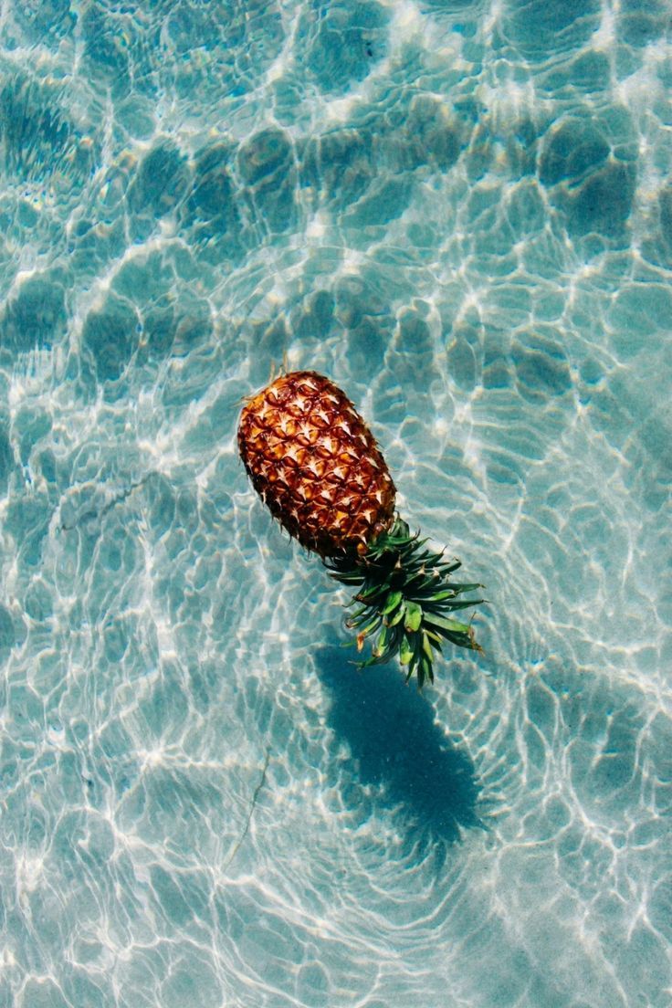 a pineapple floating on top of the water