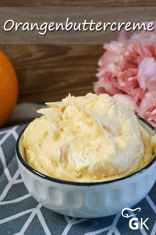 an orange buttercreeme in a bowl next to some flowers