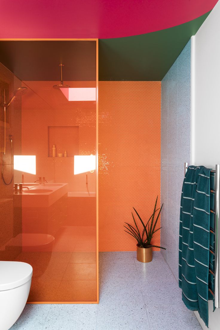 a bathroom with an orange and pink color scheme