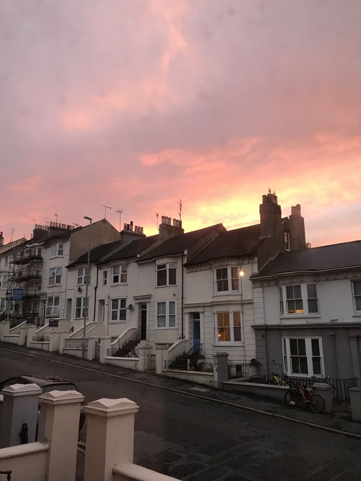 the sun is setting behind some white houses