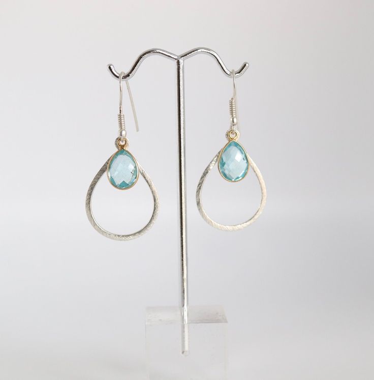 These earrings are a perfect combination of gold and light blue. The gold hoops are delicate and understated, while the light blue stones add just the right amount of color. They're a great accessory for any outfit. Turquoise Teardrop Crystal Earrings, Blue Drop Earrings Pierced, Single Blue Sterling Silver Earring, Blue Sterling Silver Single Earring, Blue Single Sterling Silver Earring, Single Sterling Silver Blue Earring, Elegant Handmade Blue Hoop Earrings, Blue Sterling Silver Pierced Crystal Earrings, Blue Teardrop Earrings For Gift