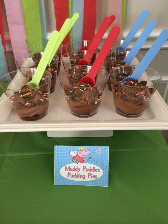 there are cupcakes with spoons in them on a tray that says muddy pudding making fun