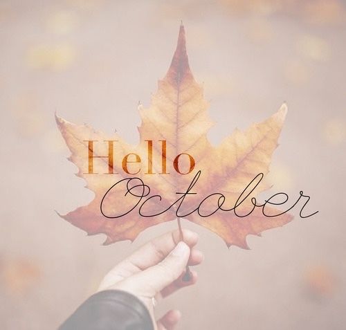 a person holding a leaf with the words hello october written on it