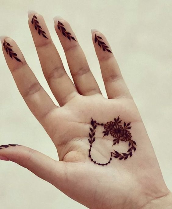 a person's hand with a henna tattoo on it and an arrow in the middle