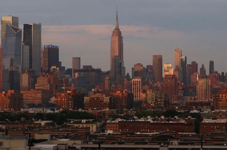 the skyline of new york city is seen at sunset