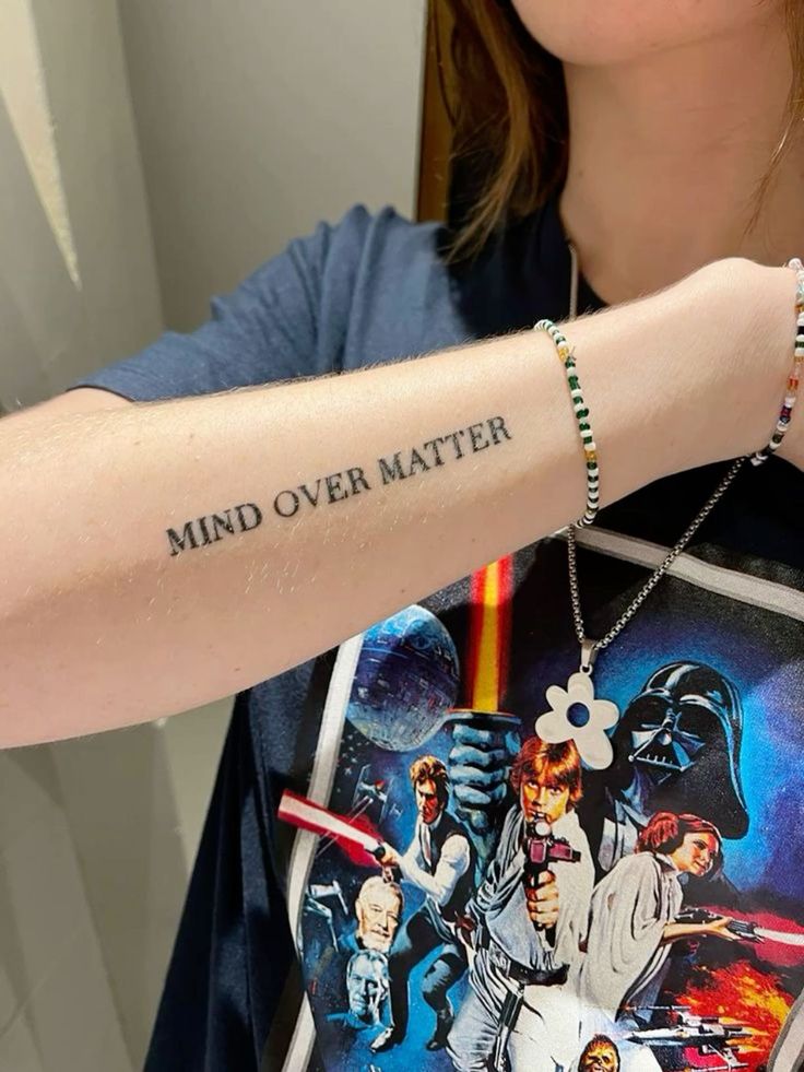 a woman with a star wars tattoo on her arm and the words mind over matter