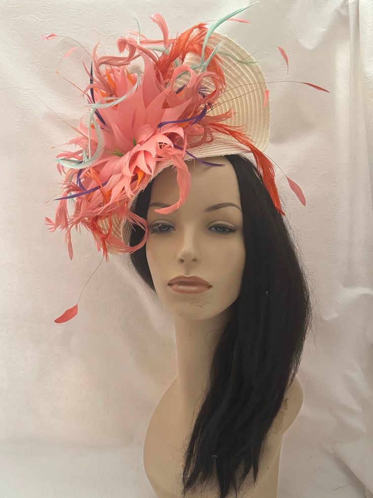 If you're looking for an eye-catching, head-turning, captivating ivory saucer tilt Fascinator headband hat with a dramatic feather flower comprise of coral salmon pink, touches of purple, mint green, and orange elegantly design for the sophisticated fashionista who adores the wearable art. Versatile for your special occasion from Kentucky derby, to tea party, brunch with ladies, whatever your occasion we have you covered! Perfect for if you're attending a    wedding, christening, church convention or out for dinner!  Lightweight Easy to wear On a headband Ostrich Feather Mini Hat For Royal Ascot Races, Royal Ascot Mini Hats With Ostrich Feathers For Races, Feathered Top Hat For Kentucky Derby Wedding, Pink Feathered Costume Hats For Wedding, Ostrich Feather Fascinator For Royal Ascot Races, Summer Wedding Ostrich Feather Fascinator, Pink Mini Hats For Wedding And Carnival, Summer Church Headpiece With Feathers, Summer Church Headpieces With Feathers