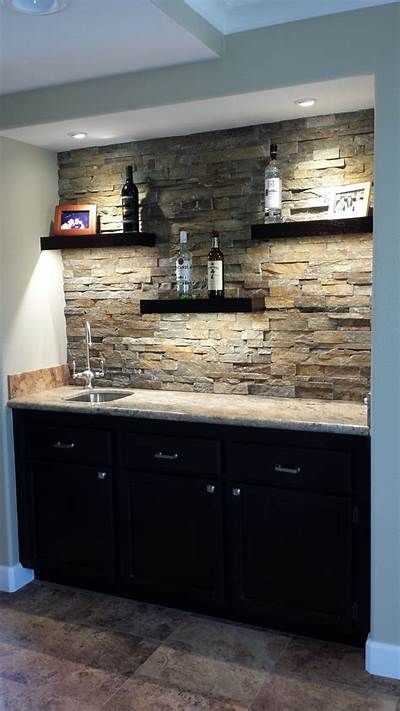 a kitchen with stone backsplash and black cabinets