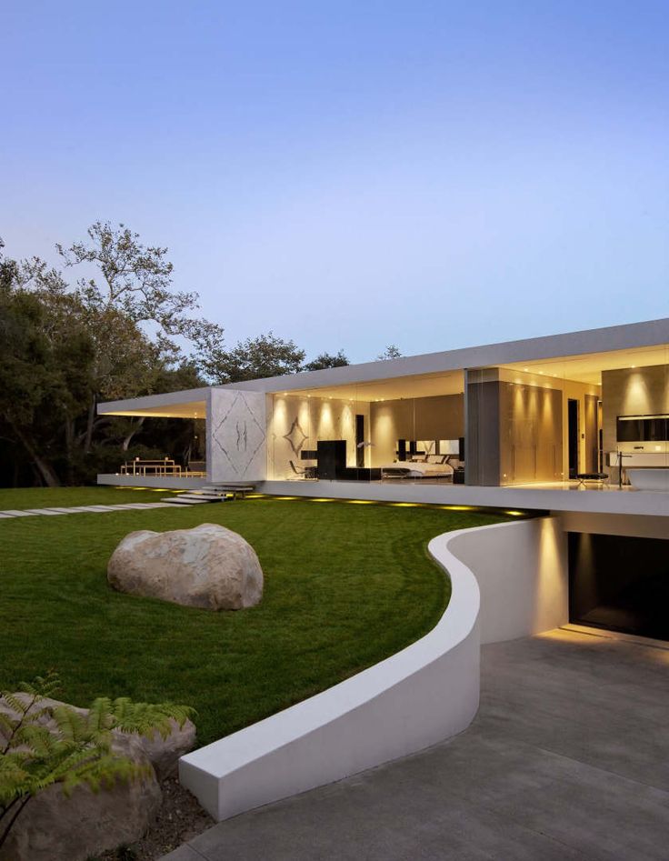 a large house with an outdoor patio and dining area in the front yard at dusk