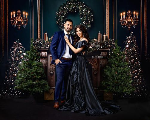 a man and woman standing in front of a christmas tree