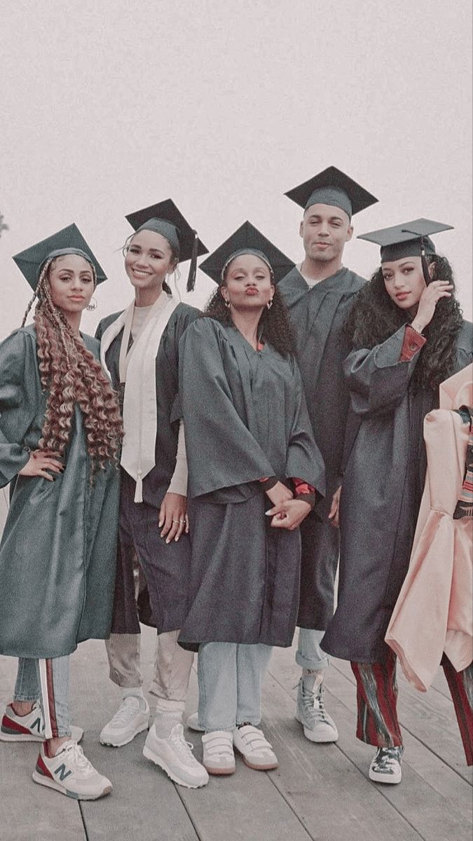 a group of people standing next to each other wearing graduation caps and gowns