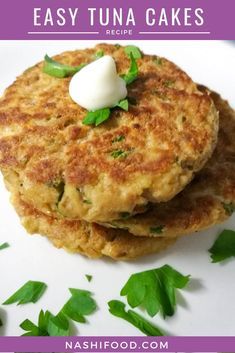 two crab cakes are stacked on top of each other and topped with sour cream in the middle