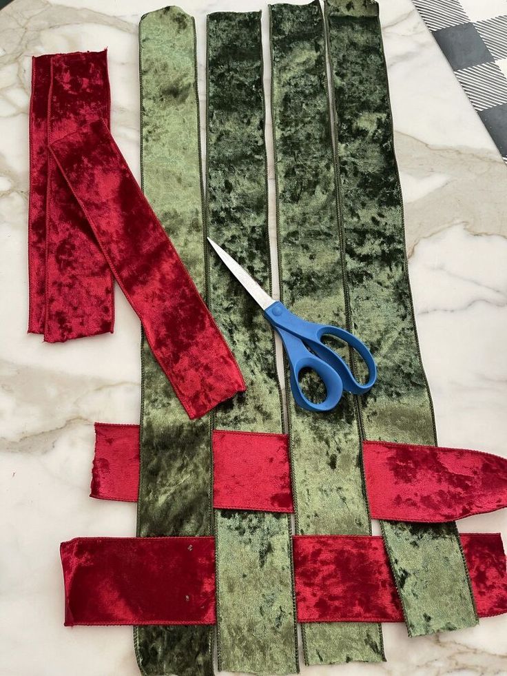 scissors and ribbon laid out on a marble table with fabric strips cut into the shape of rectangles