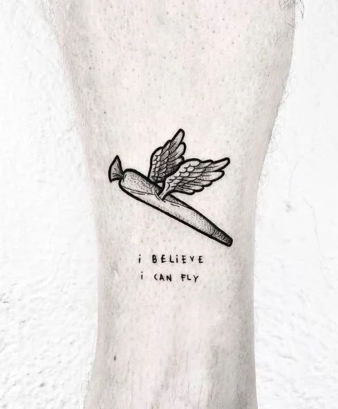 a person with a tattoo on their foot that reads believe i can fly and an angel holding a knife