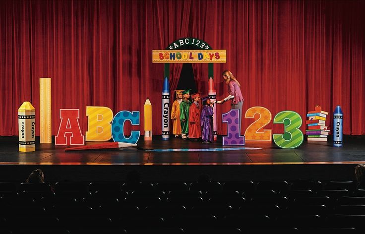 children's letters and crayons on stage with red curtain