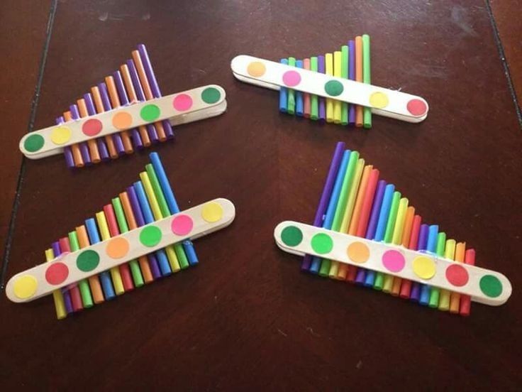 four different colored toothbrushes with polka dots on them sitting on a wooden table