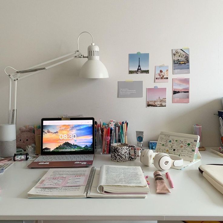 a laptop computer sitting on top of a desk next to a lamp and other items