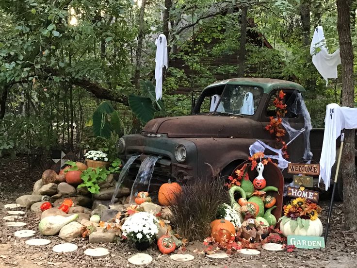 an old truck decorated with pumpkins and decorations