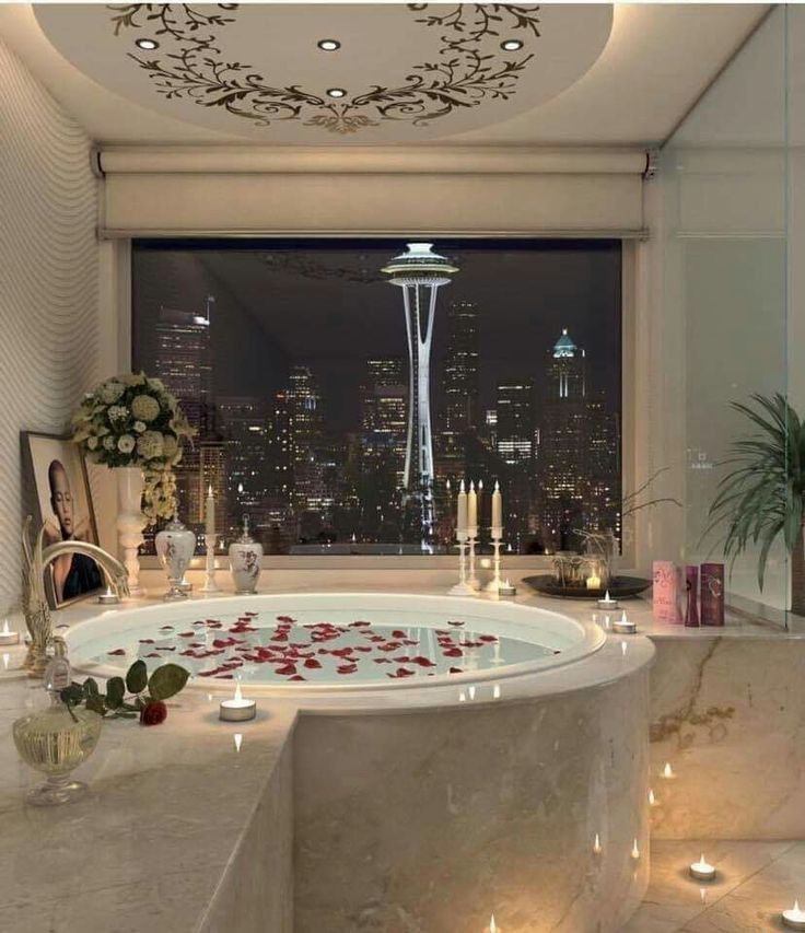 a bathroom with a large jacuzzi tub in front of a cityscape