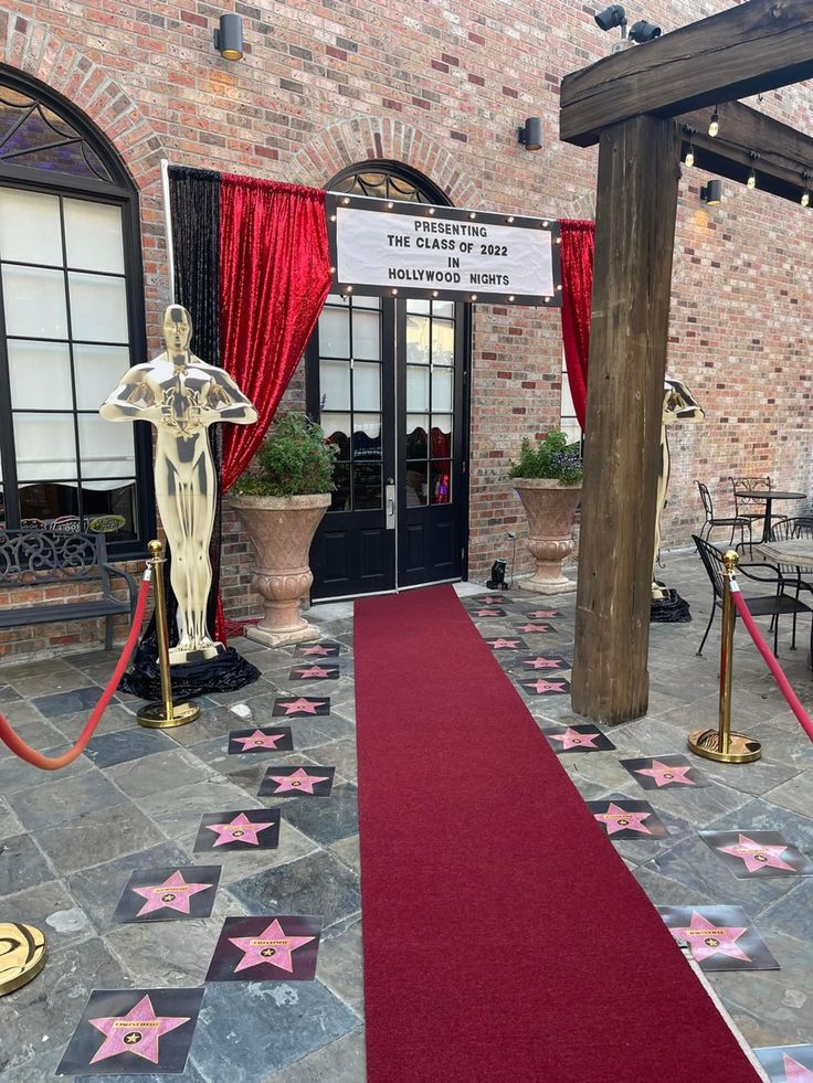 a red carpet is on the ground in front of a brick building with an entrance