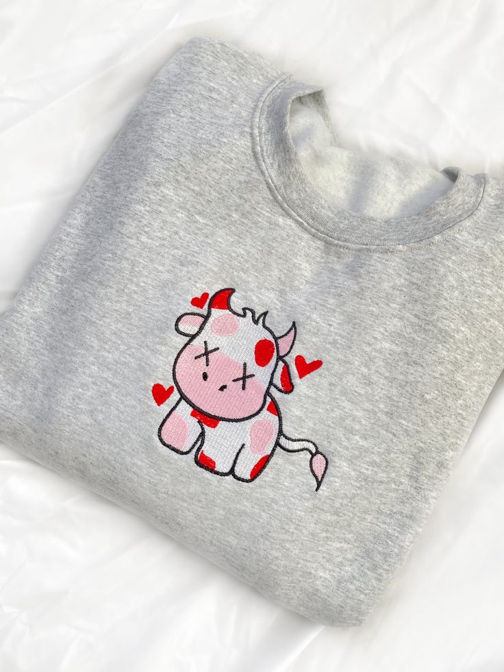 Look sweet and comfy in our Valentine Cow Crewneck Sweatshirt. This sweatshirt features long sleeves, a crew neckline, and beautiful front embroidery. The Unisex Sizing makes the sweatshirt run slightly larger than your average sweatshirt for women. Most men find their normal size to be more snug. If you want a slightly looser fit, size up one size. Please check out our size chart for measurements to ensure an accurate fit. PLEASE BE SURE TO INPUT YOUR CORRECT SIZE/COLOR + SHIPPING ADDRESS. We w Trendy Long Sleeve Top With Embroidered Logo, Cute Embroidered Long Sleeve Sweatshirt, Cute Long Sleeve Embroidered Sweatshirt, Casual Crew Neck Sweater With Embroidered Text, Trendy Long Sleeve T-shirt With Embroidered Logo, Cute Embroidered Sweatshirt For Loungewear, Gray Embroidered Text Sweatshirt For Fall, Trendy Long Sleeve T-shirt With Embroidered Graphics, Trendy Embroidered Long Sleeve T-shirt