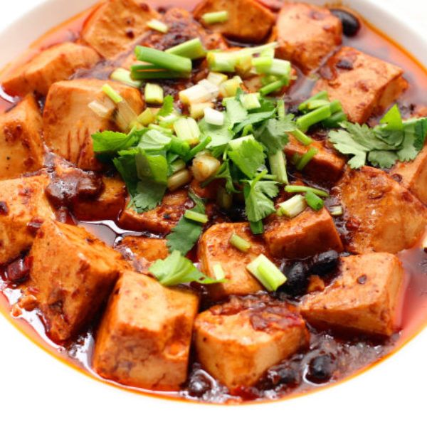 a white bowl filled with tofu and vegetables