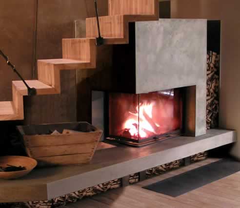 a fire place sitting in the middle of a living room next to a stair case