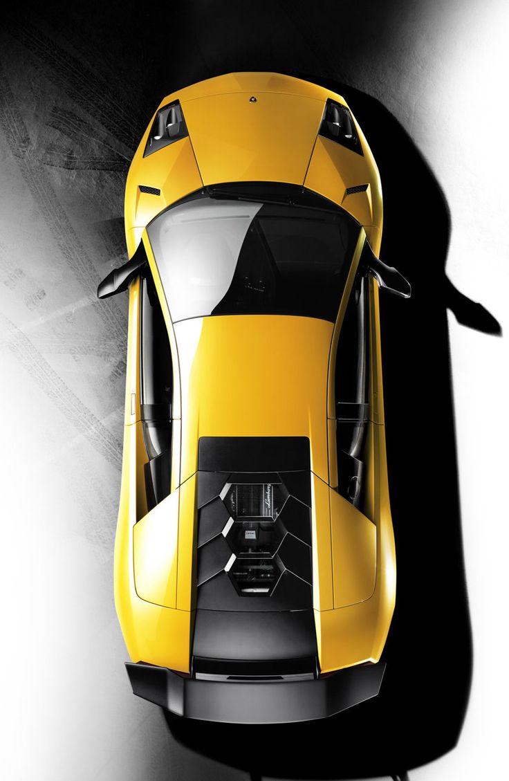 an overhead view of a yellow sports car in black and white background with the top down