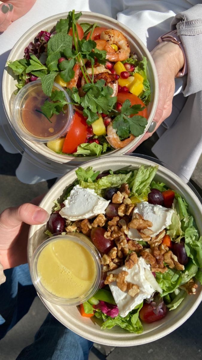 two bowls filled with salad and dressing on top of each other