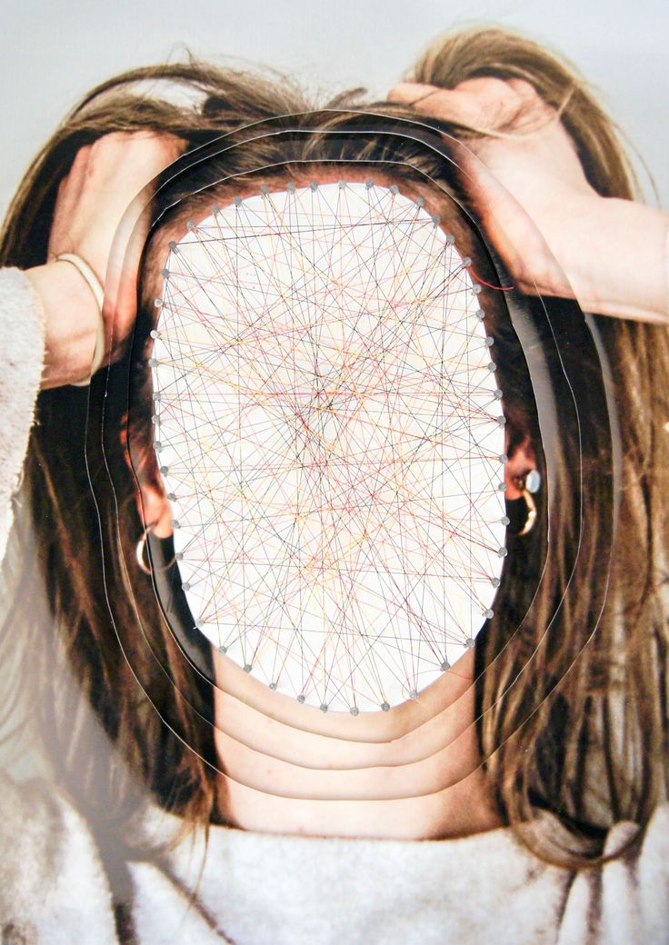 a woman covering her face with two hands while holding a circular object in front of her face