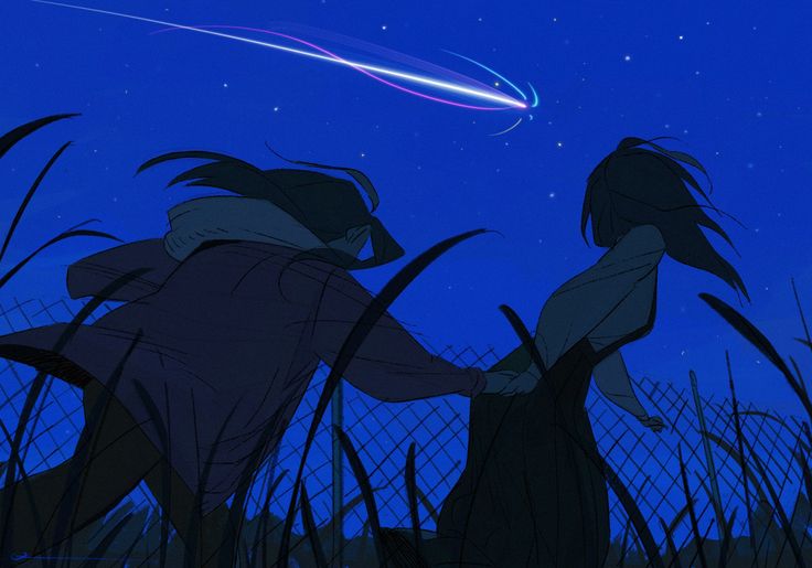 two people standing in tall grass looking at the sky with an object flying above them