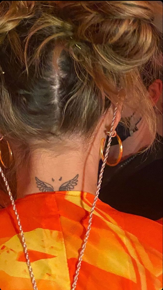 the back of a woman's head with tattoos on her neck