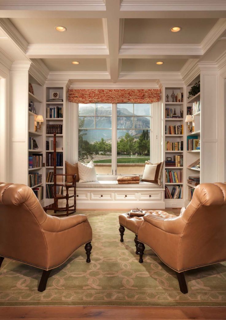 a living room filled with lots of furniture and bookshelves next to a window