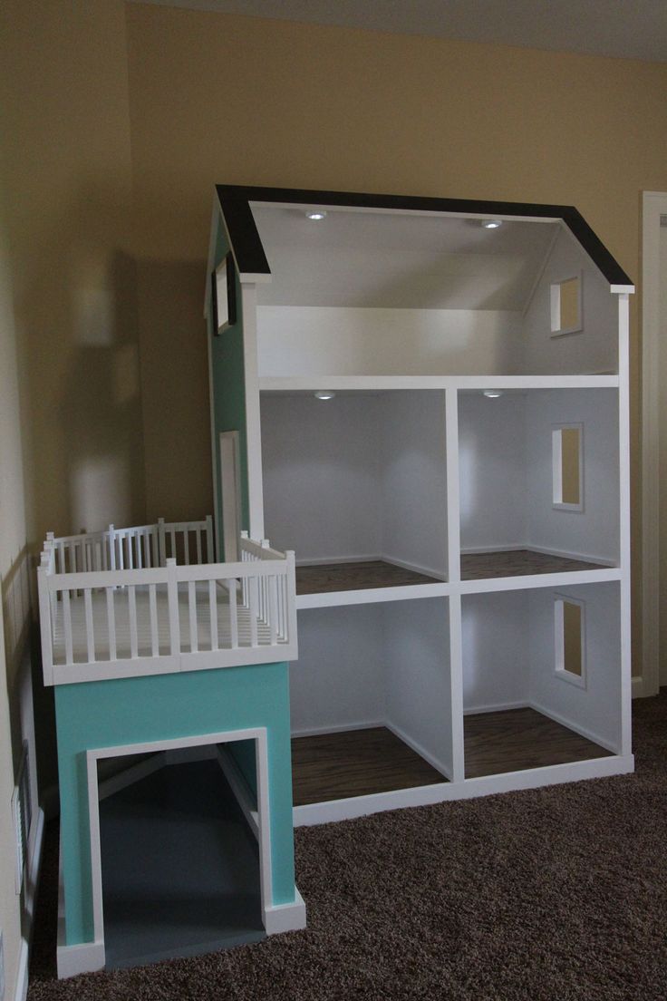 there is a doll house built into the wall with shelves and stairs on each side