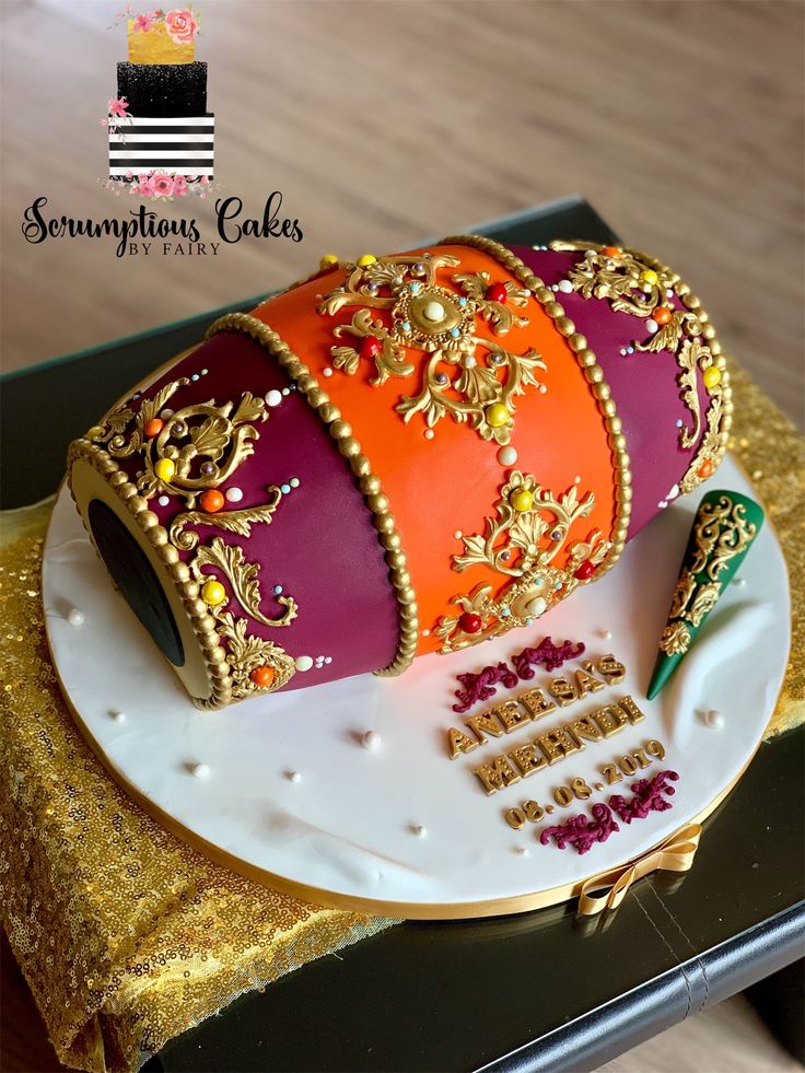 a birthday cake decorated with an orange and pink crown on top of a white plate