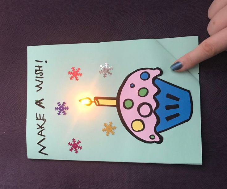 a hand is pointing at a card with an image of a light coming out of it