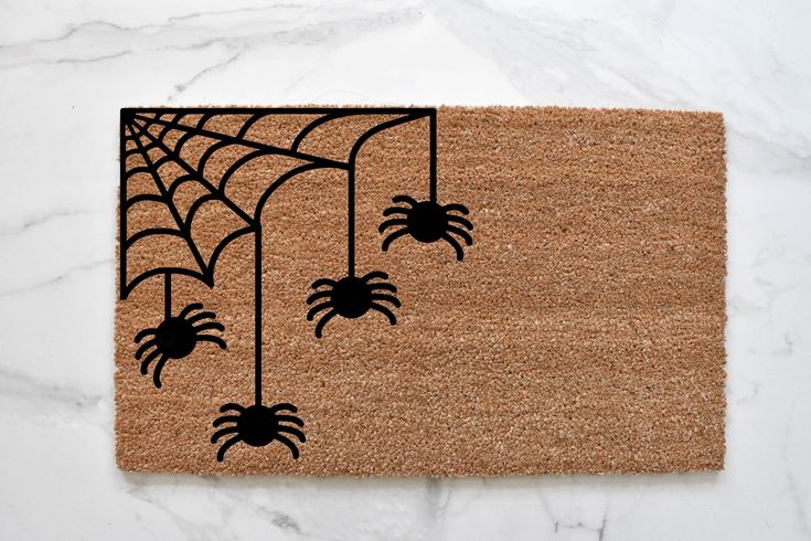 a door mat with black spider webs hanging from it's sides on a marble surface