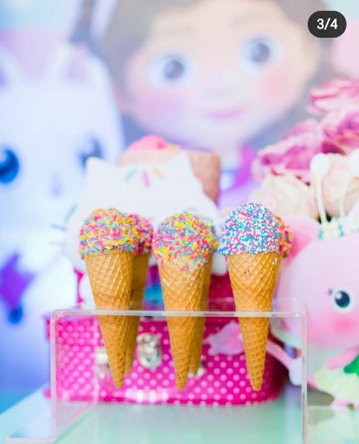 there are three ice cream cones with sprinkles on them next to some stuffed animals