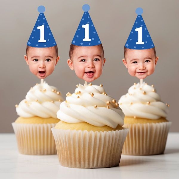 three cupcakes with little faces on them and one has the number one on it