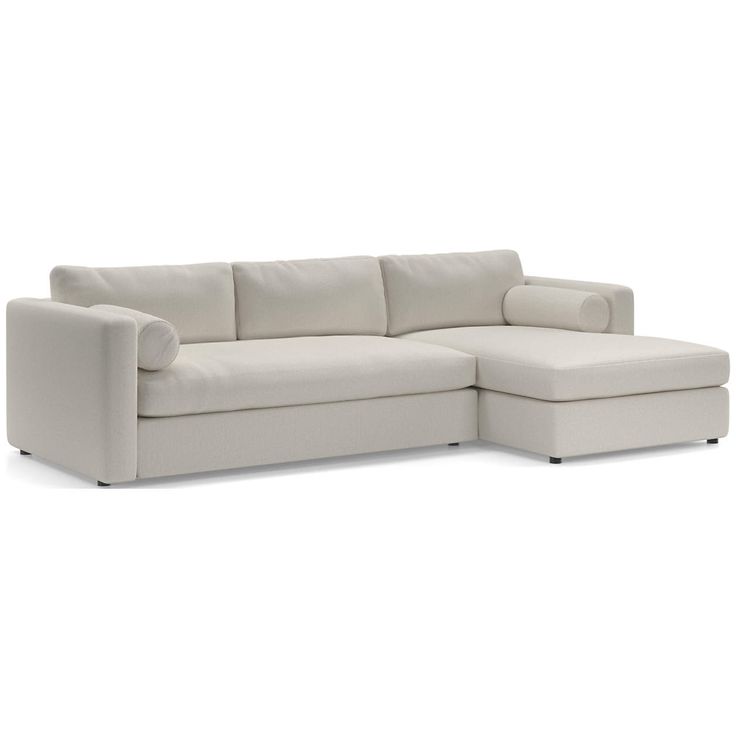 a white sectional sofa with chaise lounger on the right side and pillows on the left