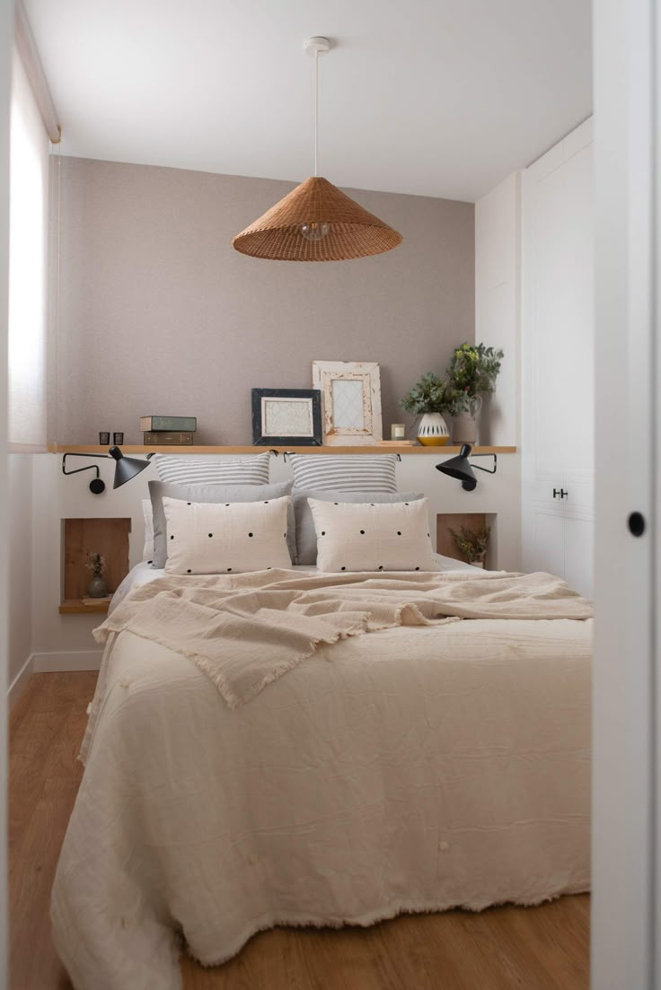 a bed sitting in a bedroom next to a wooden shelf with pictures on top of it