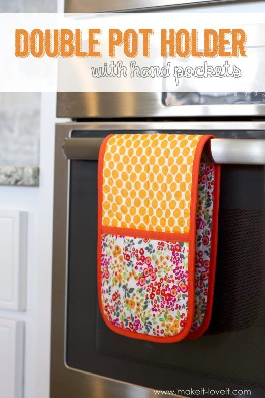 an orange and white towel hanging from the side of a stove top oven with flowers on it