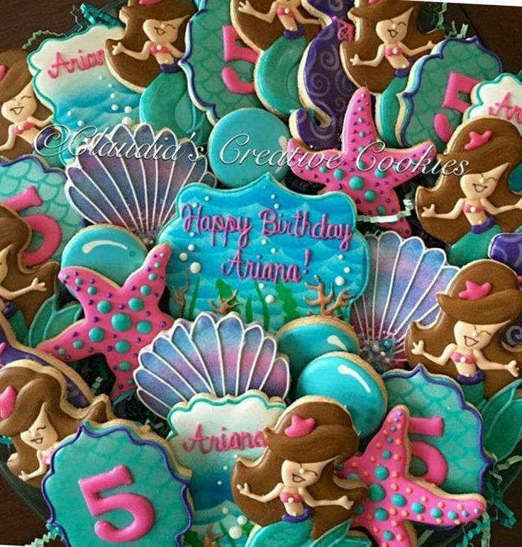 decorated cookies in the shape of mermaids for a 5th birthday