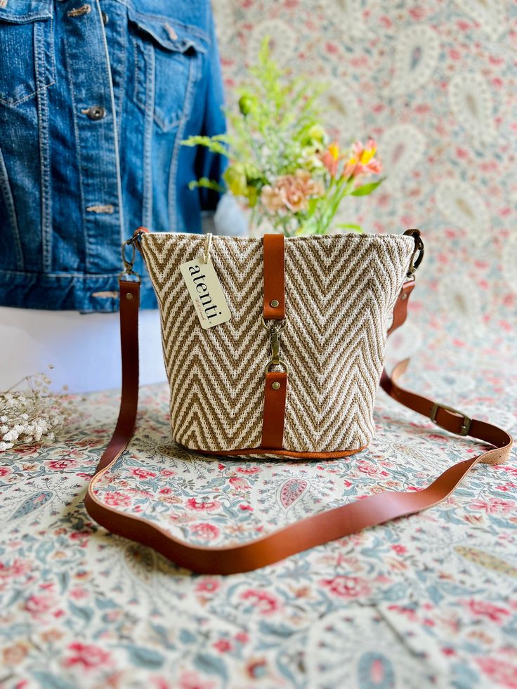 Two interior pockets, leather detachable adjustable crossbody strap, leather closure. This seamless and itricate tartan plaid is woven into the fabric and is just perfect for those crisp walks in the autumn air. Dimension: About 8.00'W"x8.00"H"x5.50"D Fall Travel Crossbody Bucket Bag, Fall Travel Bucket Bag With Detachable Strap, Spring Leather Shoulder Bag With Leather Trim, Fall Season Leather Handled Crossbody Bucket Bag, Fall Crossbody Bucket Bag With Adjustable Strap, Spring Brown Handwoven Shoulder Bag, Spring Handwoven Brown Shoulder Bag, Fall Adjustable Strap Crossbody Bucket Bag, Fall Travel Bucket Bag With Adjustable Strap