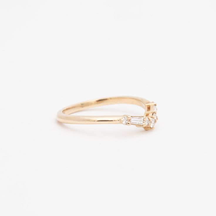 Simple, elegant, and designed to flatter—not overwhelm�—your other rings, this gently curved band always feels like a perfect fit. Stack a pair of each side of your solitaire for a gorgeous frame of diamonds or pair it with an east-west cocktail ring to give your chunkiest gems a dainty finish. Made in the U.S.A. 14 karat gold set with five round white diamonds and two baguette white diamonds totaling 0.20 carat. Brilliant Cut Diamond Ring, Jewelry Designers, Fine Jewelry Designers, Gold Set, Cocktail Ring, Brilliant Cut Diamond, Cocktail Rings, Unique Rings, Diamond White