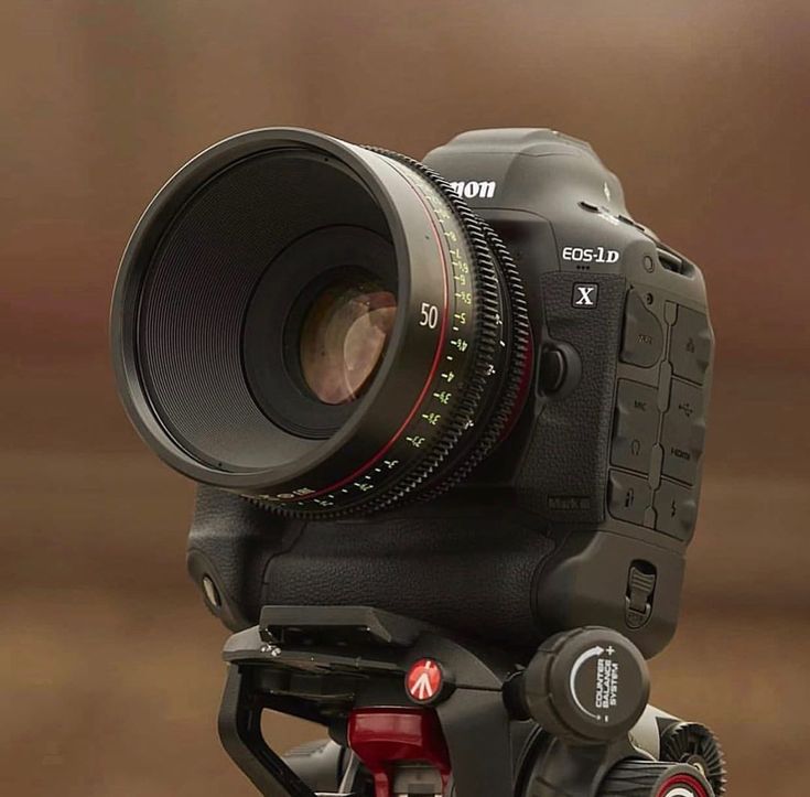 a close up of a camera on a tripod with a lens attached to it