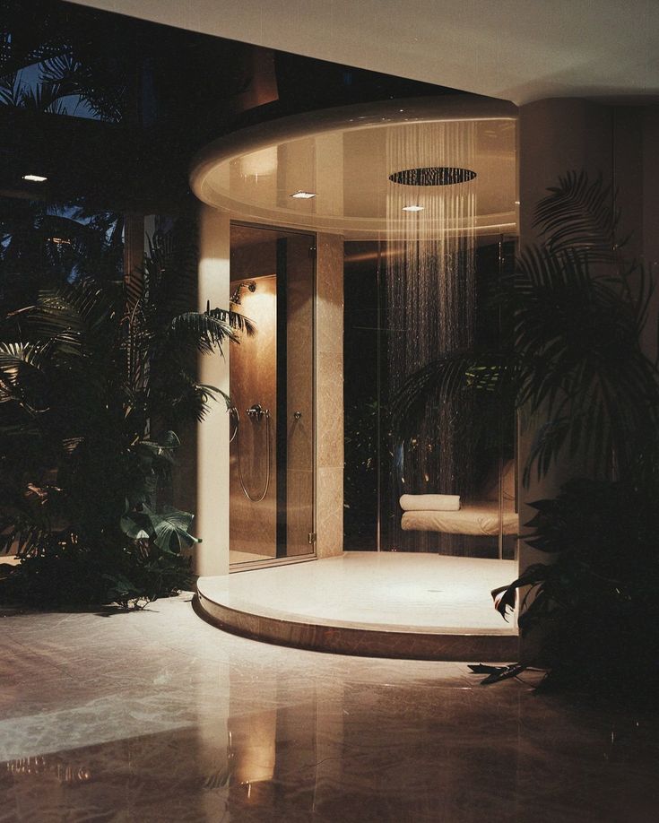 a bathroom with a shower head in the middle of it and plants on the side