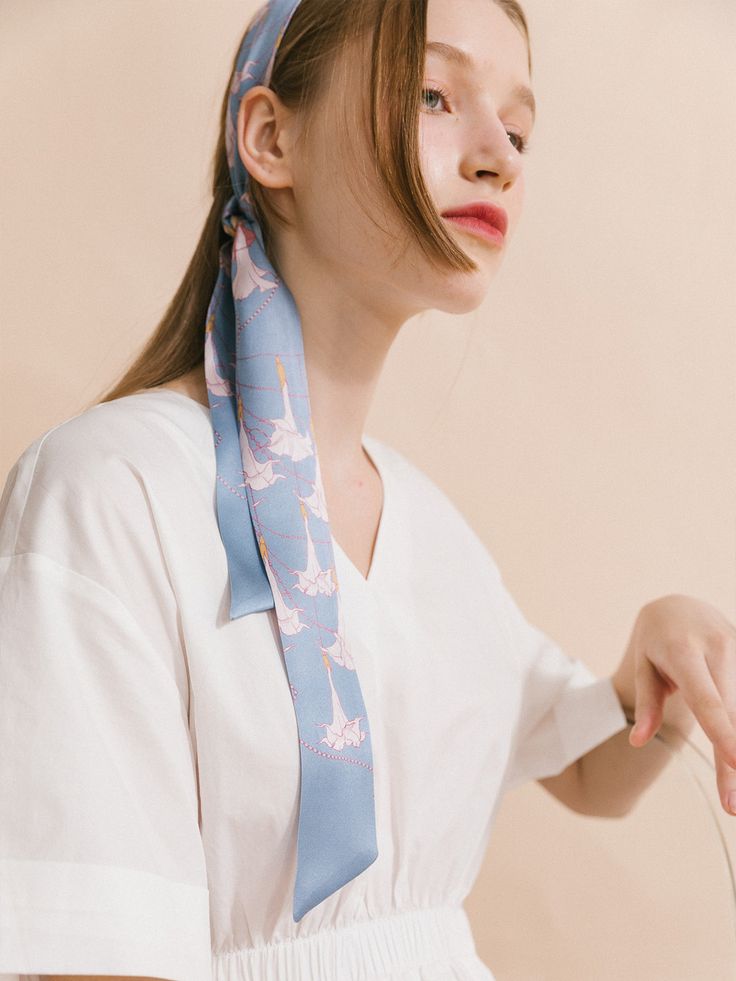 Elevate your wardrobe with the captivating beauty of our "Datura" silk twilly skinny scarf, a stunning accessory inspired by the delicate blooms of the darling darura flower, also known as angel's trumpet. The design embodies the voice of nature, immersing you in its ethereal beauty and transporting you to a realm of tranquility and peace. Made from premium quality silk satin, this skinny scarf is perfect for a hair scarf style. It can also drape elegantly around your neck, immersing you in its Elegant Blue Silk Scarf For Spring, Trendy Spring Neckwear For Gifts, Feminine Silk Scarf As Spring Gift, Feminine Silk Scarf For Spring Gift, Chic Blue Silk Scarf As Gift, Chic Blue Scarves For Gifts, Feminine Scarves As Summer Gifts, Chic Neckwear For Spring Gifting, Feminine Scarves For Spring Gift