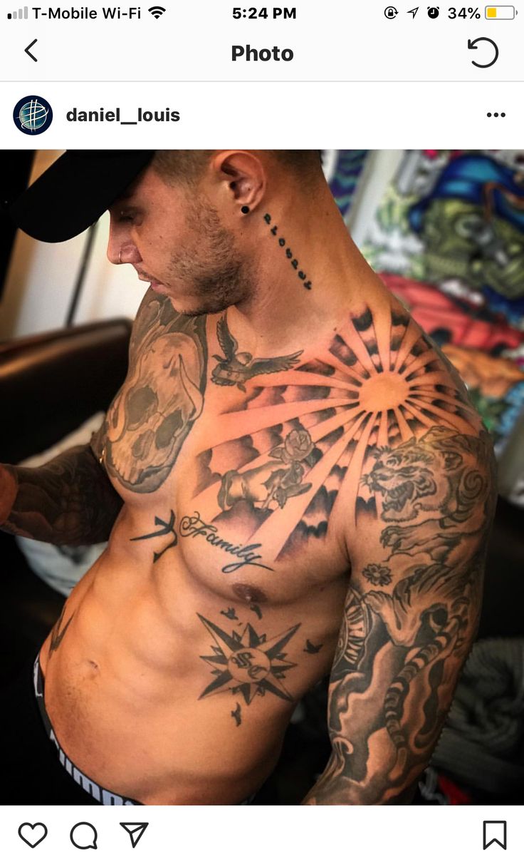 a man with tattoos on his chest and arm is looking at his cell phone while wearing a baseball cap